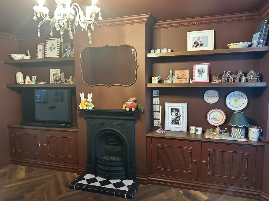 Brown painted alcove cupboards and floating shelves either side of a chimney breast