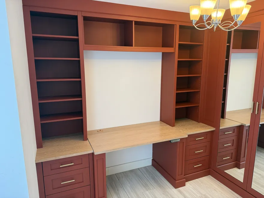 Rust red fitted office with a desk bay, open shelving and drawer pedestals