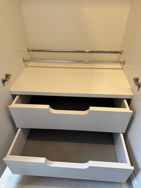 Pull-out drawers and shoe rails inside a painted boot room cupboard