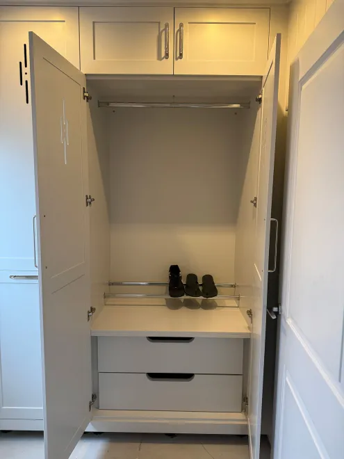 Boot room cupboard open to show a hanging rail, shoe rack and drawers