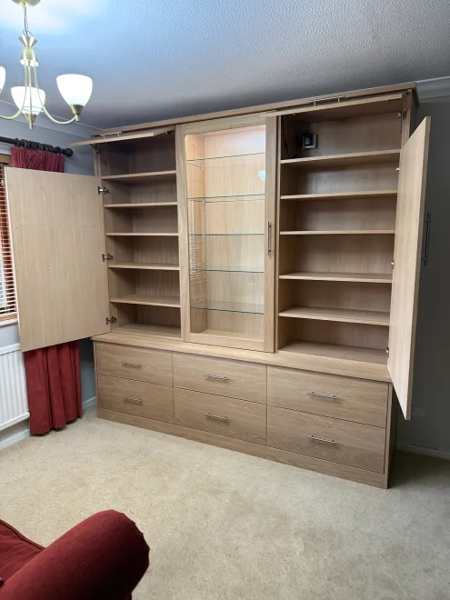 Oak dresser with its doors open to reveal shelving and a lit glass display