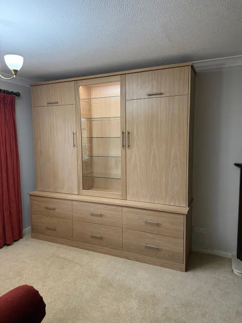 Angled view of the oak dresser with its centre glass display and drawers