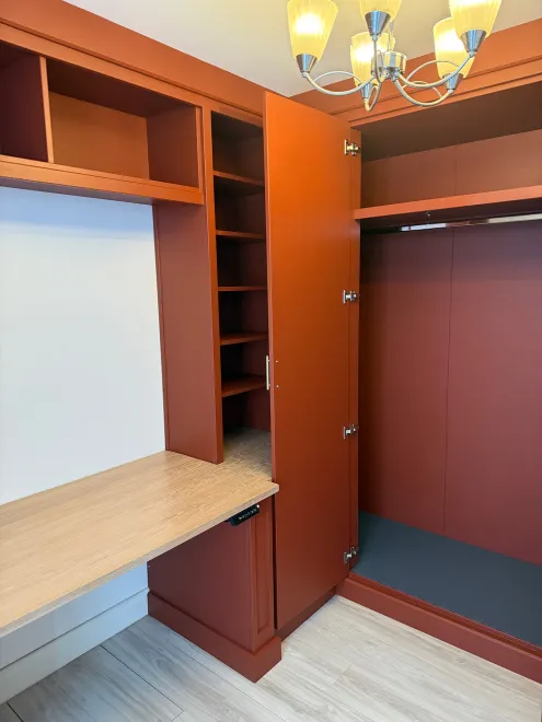 Tall terracotta cloakroom cupboard open beside the desk and shelving