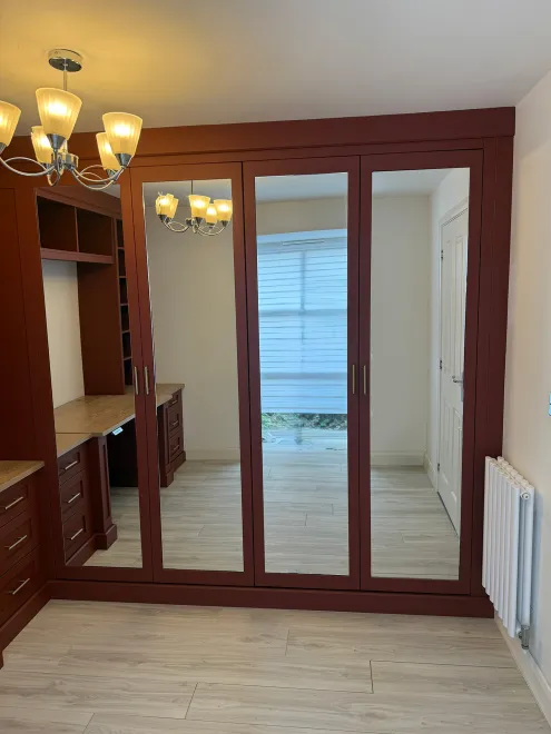 Mirrored wardrobe doors in a terracotta painted fitted office and cloakroom