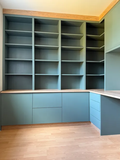 Green floor-to-ceiling open shelving above handleless base cupboards