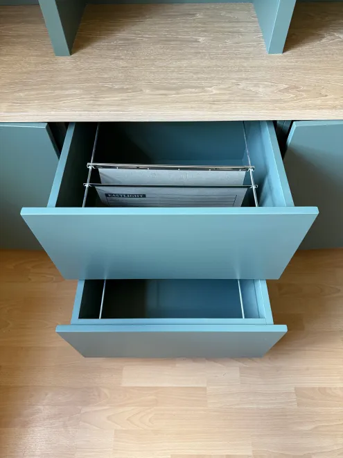 Green desk drawer pulled open to show hanging file rails