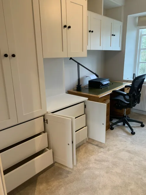 Drawers and cupboards open in white fitted home office furniture