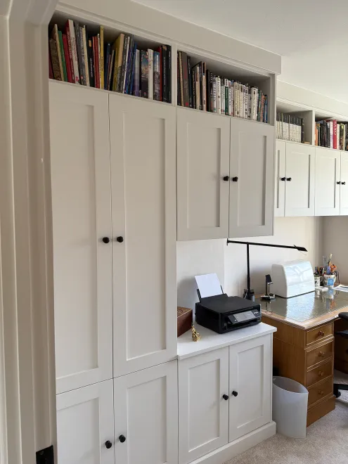 White shaker cupboards and open bookshelves built around a home office desk