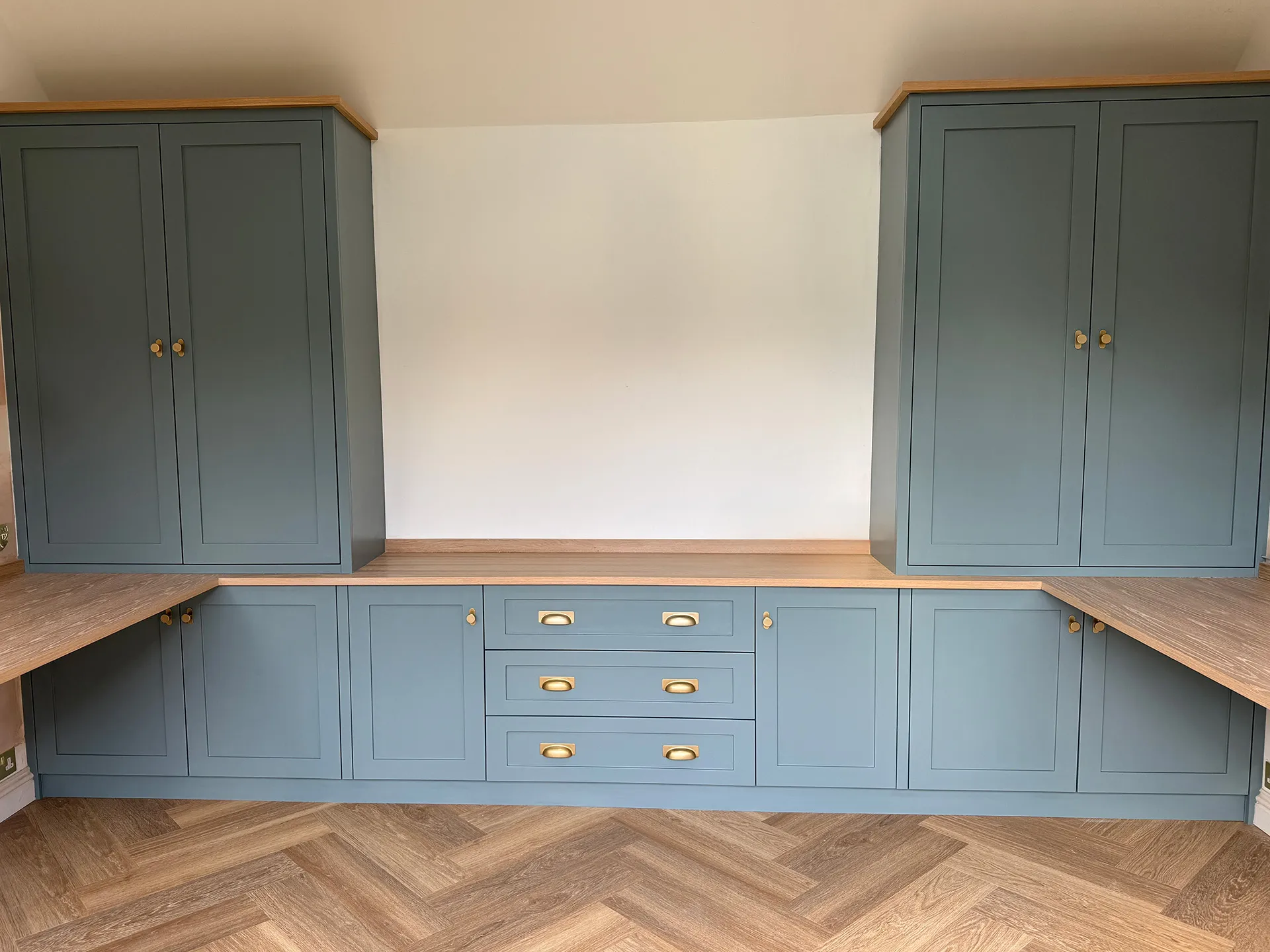 Blue-grey shaker home office with twin desks, tall cupboards and oak worktops